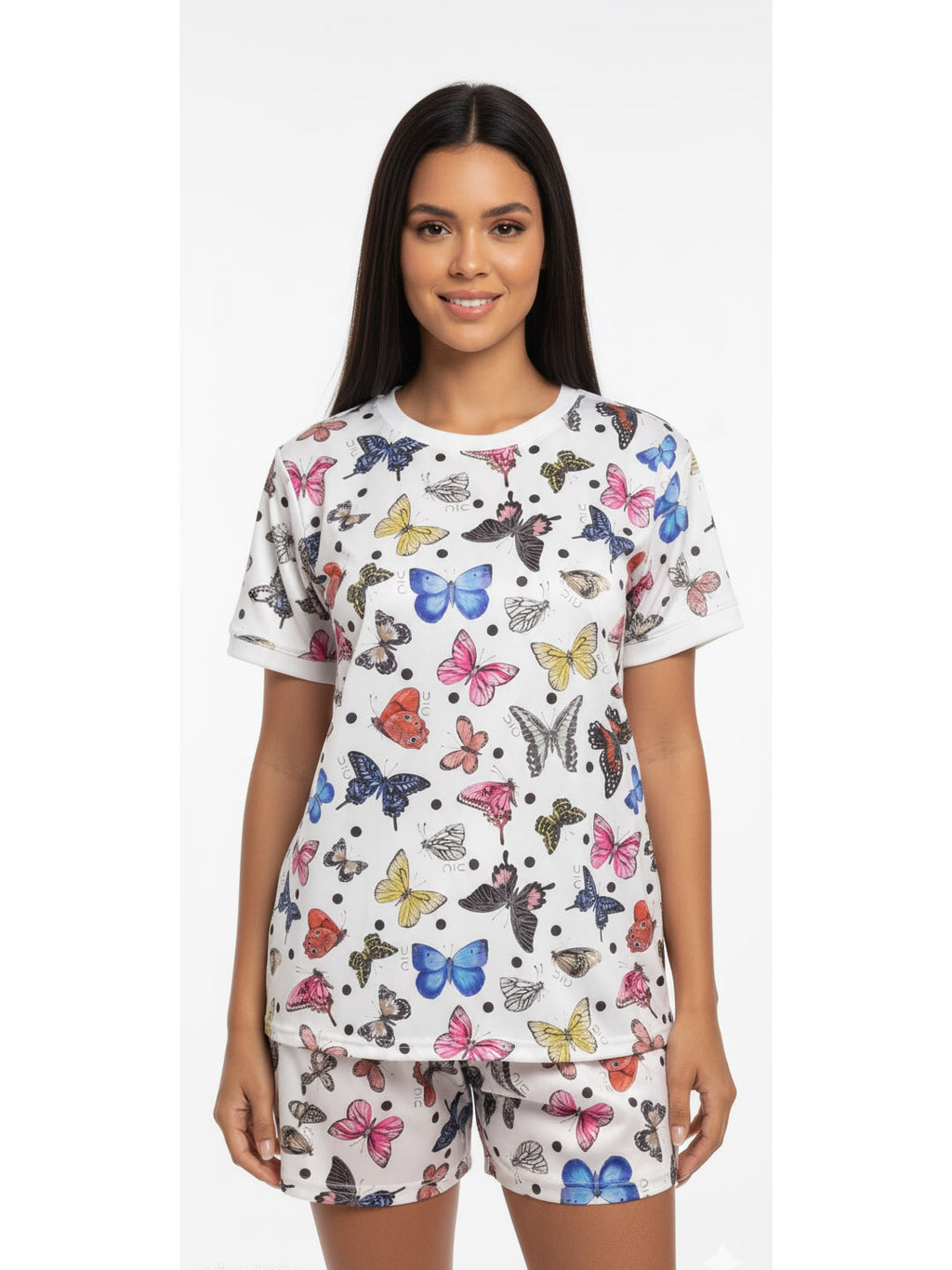 Woman wearing a butterfly print cotton sleepwear set with a short-sleeve top and matching shorts.
