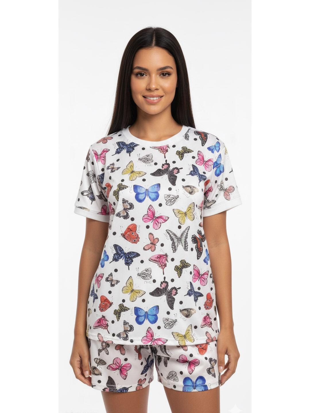 Woman wearing a butterfly print cotton sleepwear set with a short-sleeve top and matching shorts.